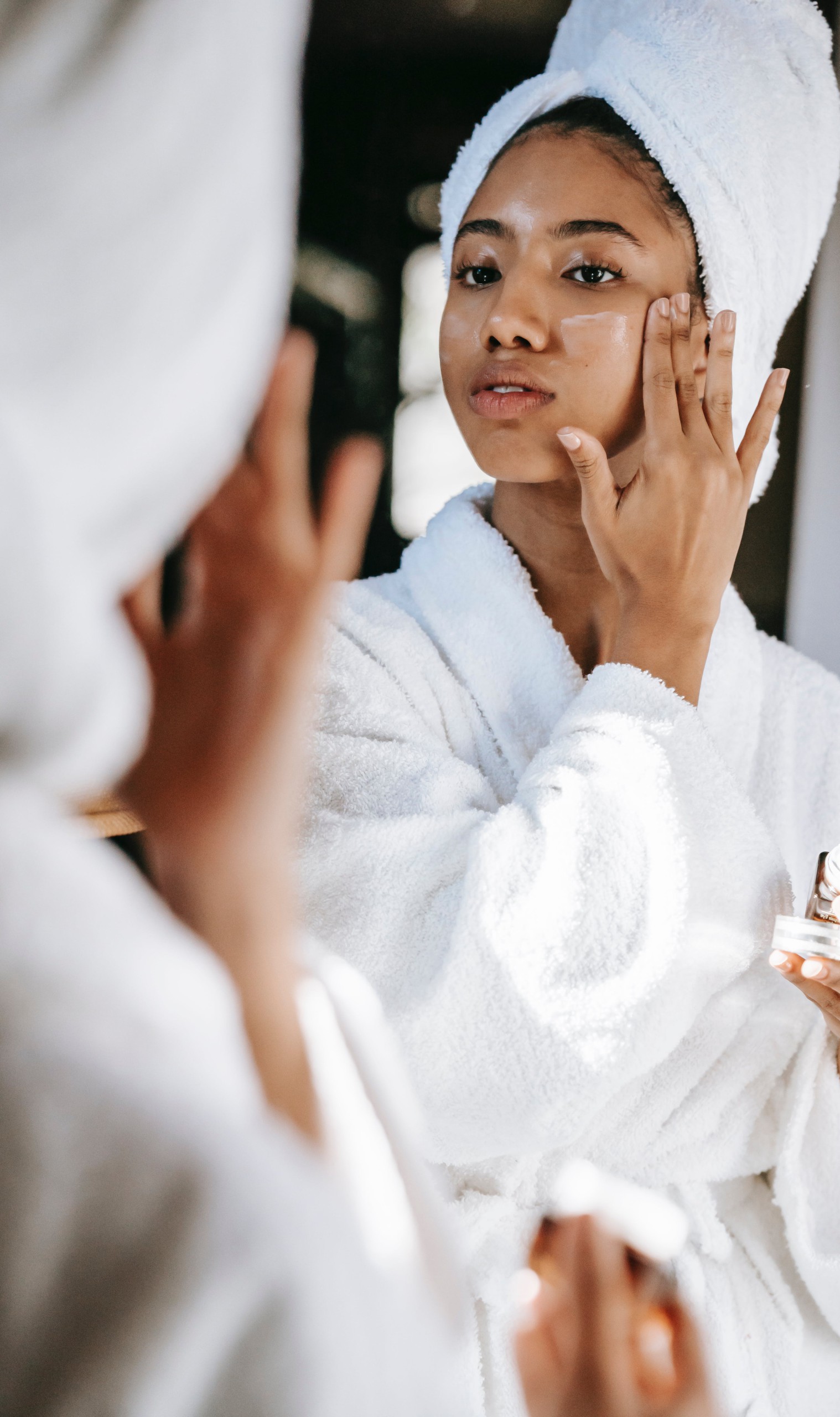 woman applying skincare face mask
